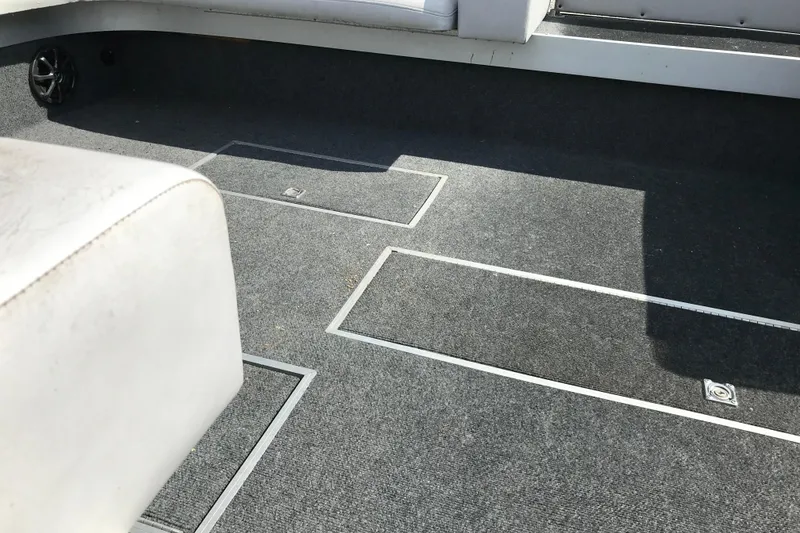 Slide: The Image of Interior of a 1991 Lowe 2200 boat with gray carpet and white seating. - 10