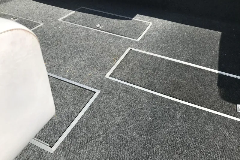 Slide: The Image of Carpeted floor with storage compartments on a 1991 Lowe 2200 boat. - 11