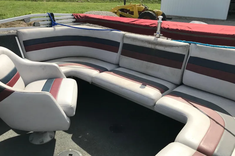 Slide: The Image of 1991 Lowe 2200 boat interior with striped seating and swivel chair. - 13