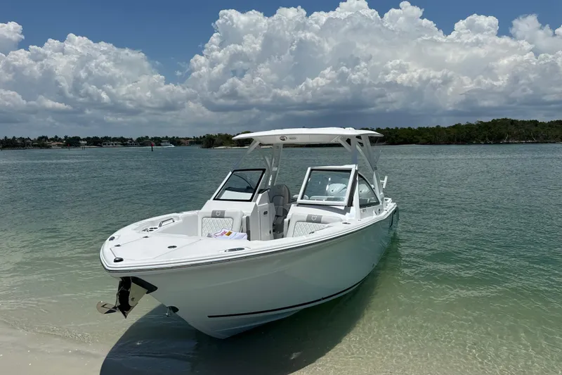 Slide: The Image of 2024 Sea Fox 268 Traveler boat anchored on a sandy beach under a cloudy sky. - 1