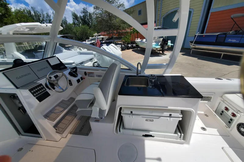 Slide: The Image of 2024 Sea Fox 268 Traveler boat interior with helm, Garmin displays, and kitchenette area. - 14