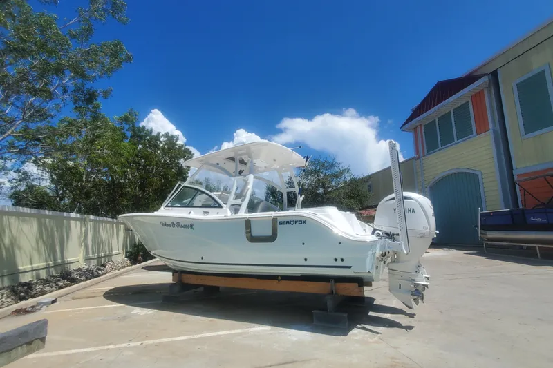 Slide: The Image of 2024 Sea Fox 268 Traveler boat on trailer, parked outdoors under clear blue sky. - 5