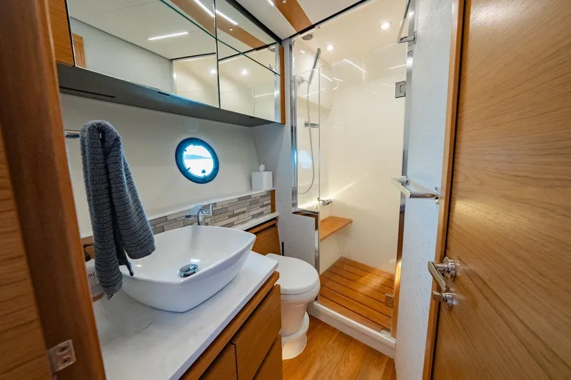 Slide: The Image of Luxurious 2022 Tiara Yachts Coupe bathroom with modern fixtures and wooden accents. - 11