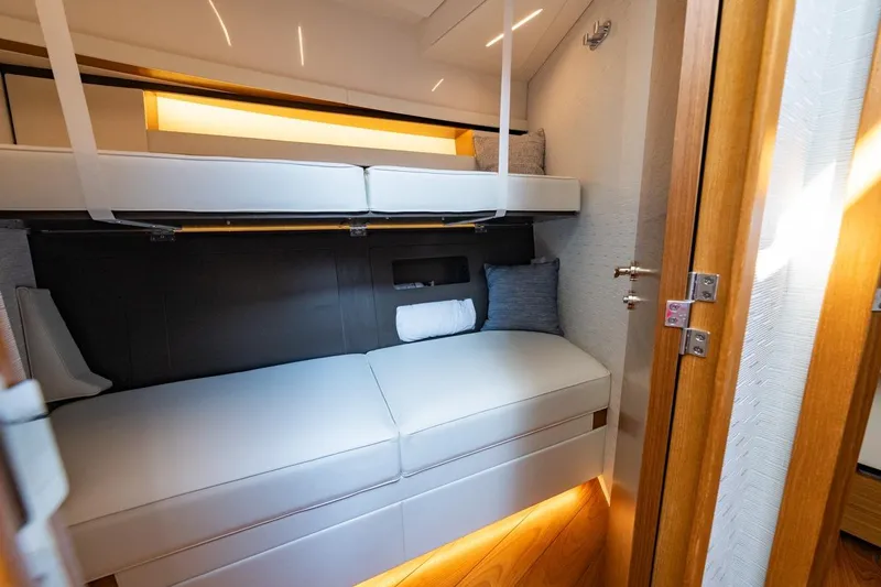 Slide: The Image of 2022 Tiara Yachts Coupe interior cabin with modern bunk beds and elegant lighting. - 13