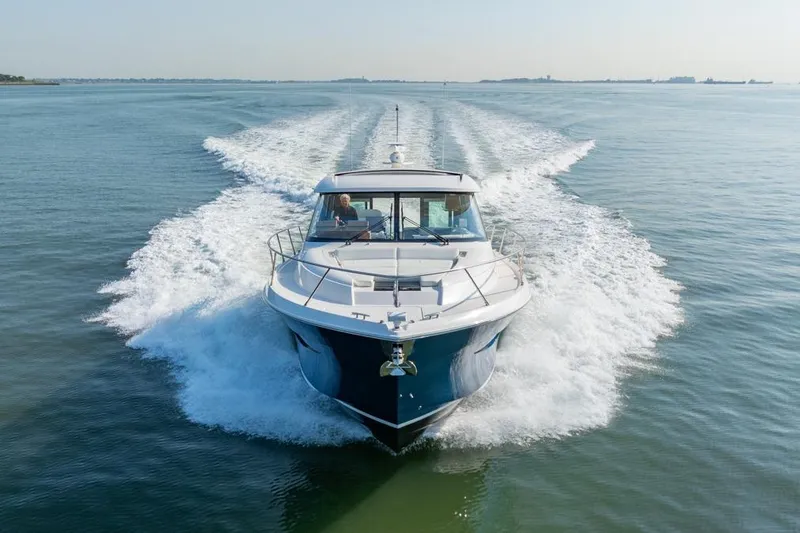 Slide: The Image of 2022 Tiara Yachts Coupe cruising on open water, creating a dynamic wake. - 34