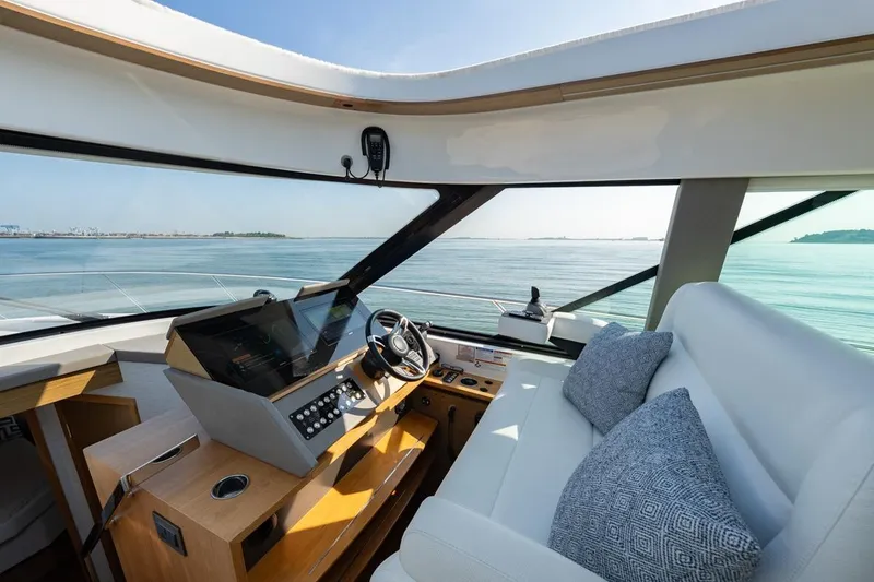 Slide: The Image of Interior of 2022 Tiara Yachts Coupe, featuring modern helm and luxurious seating. - 6