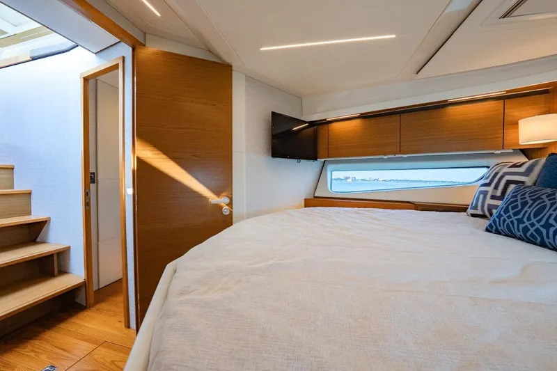 Slide: The Image of Luxurious 2022 Tiara Yachts Coupe interior with cozy bedroom and scenic window view. - 9