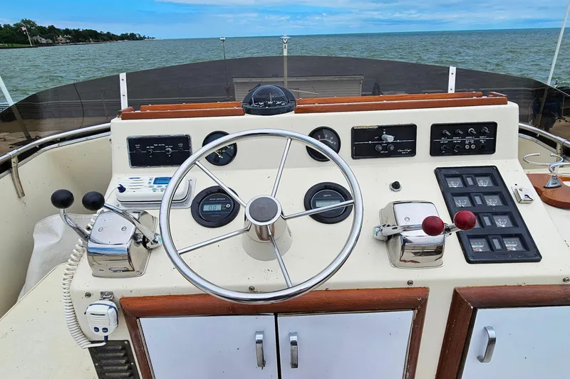 Slide: The Image of 1978 Chris-Craft 410 Commander helm with steering wheel and control panels, overlooking the water. - 10
