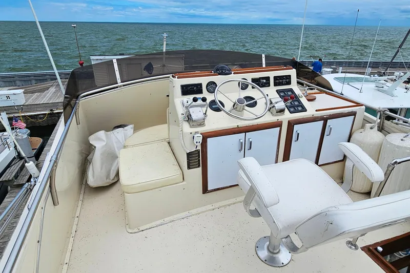 Slide: The Image of 1978 Chris-Craft 410 Commander helm with ocean view, featuring classic controls and seating. - 12