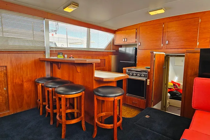 Slide: The Image of Interior of 1978 Chris-Craft 410 Commander yacht with wooden bar and stools. - 16