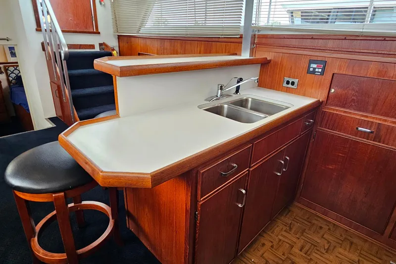 Slide: The Image of 1978 Chris-Craft 410 Commander interior with wooden cabinetry and dual sink. - 18