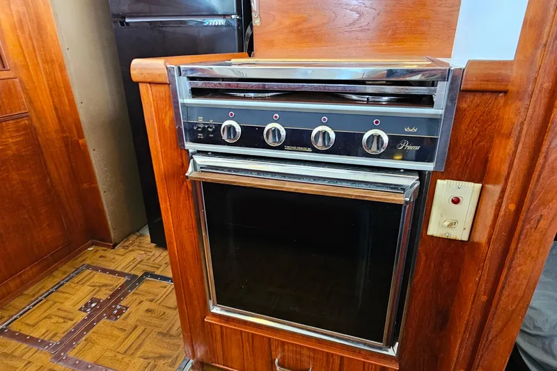Slide: The Image of 1978 Chris-Craft 410 Commander kitchen with vintage stove and wooden cabinetry. - 19