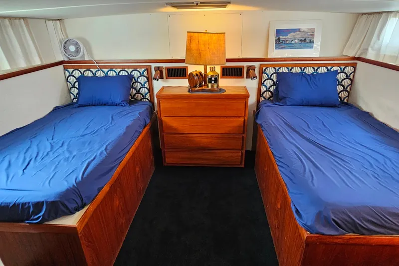Slide: The Image of 1978 Chris-Craft 410 Commander cabin with twin beds, blue bedding, and wooden furniture. - 23
