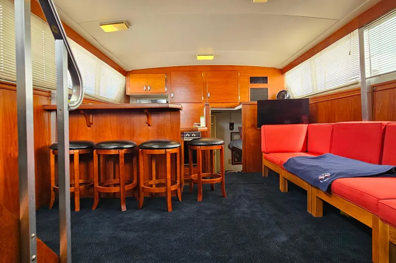 Slide: The Image of Interior of 1978 Chris-Craft 410 Commander with wooden bar, stools, and red seating. - 27
