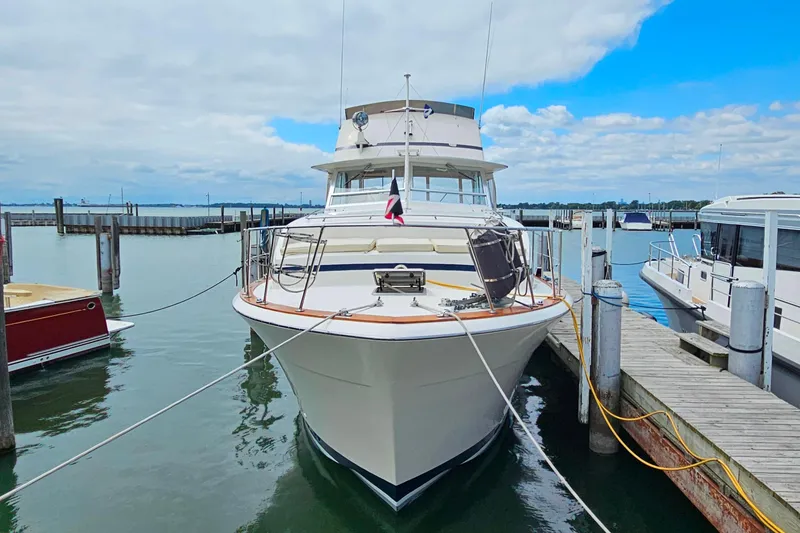 Slide: The Image of 1978 Chris-Craft 410 Commander yacht docked at marina under blue sky. - 3
