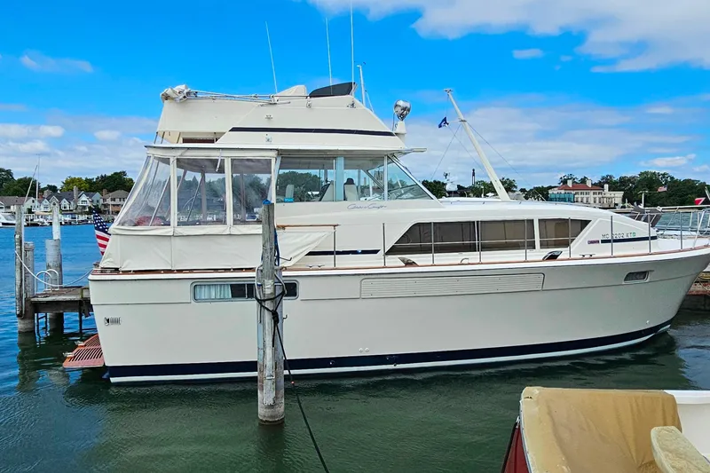 Slide: The Image of 1978 Chris-Craft 410 Commander yacht docked at a marina under a clear blue sky. - 34