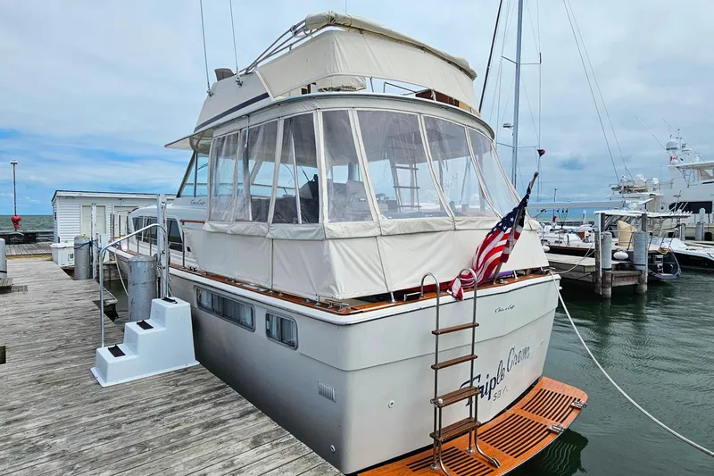 Slide: The Image of 1978 Chris-Craft 410 Commander yacht docked at marina with American flag. - 4