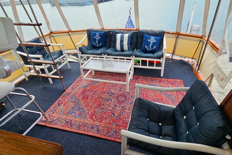 Slide: The Image of 1978 Chris-Craft 410 Commander interior with nautical-themed seating and vibrant rug. - 6