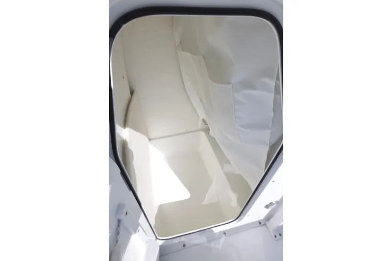 Slide: The Image of Interior view of 2026 Sea Hunt Ultra 229 boat cabin, featuring white seating and storage. - 16