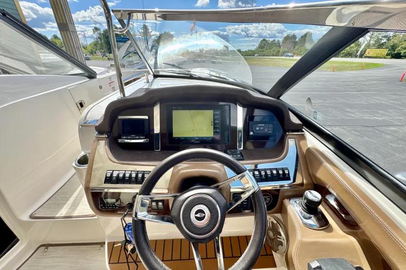 Slide: The Image of 2017 Chaparral 337 SSX boat dashboard with steering wheel and navigation screens. - 13