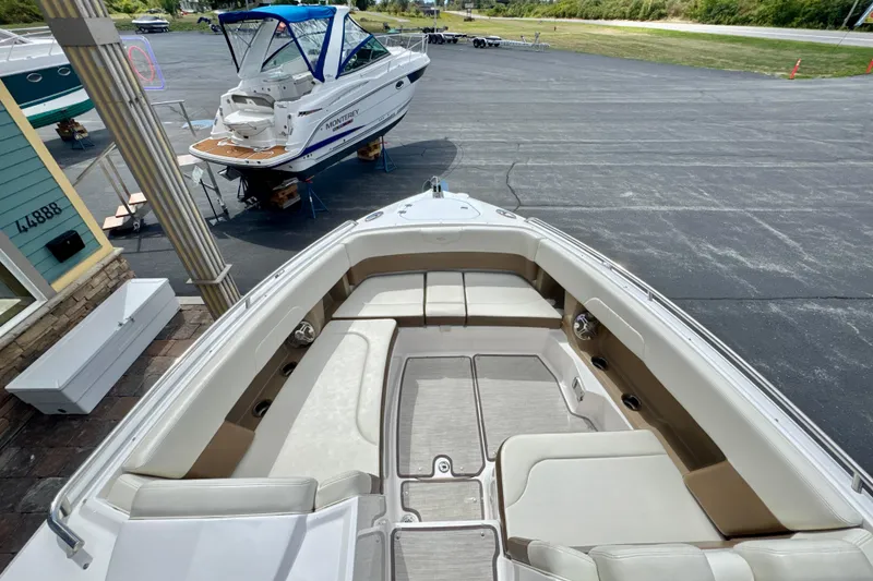 Slide: The Image of 2017 Chaparral 337 SSX boat interior with spacious seating, docked near another boat. - 15