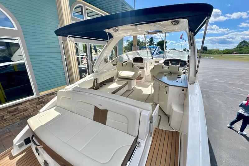 Slide: The Image of 2017 Chaparral 337 SSX boat with spacious seating and sleek design under a blue canopy. - 19