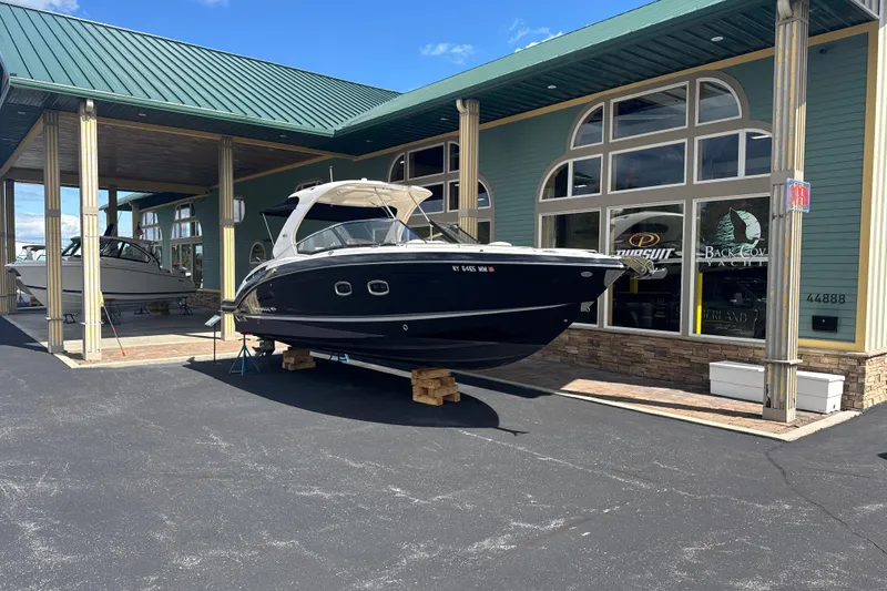 Slide: The Image of 2017 Chaparral 337 SSX boat displayed outside a showroom under a green roof. - 2