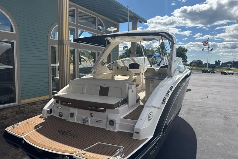 Slide: The Image of 2017 Chaparral 337 SSX boat with spacious deck and luxurious seating, docked outdoors. - 3