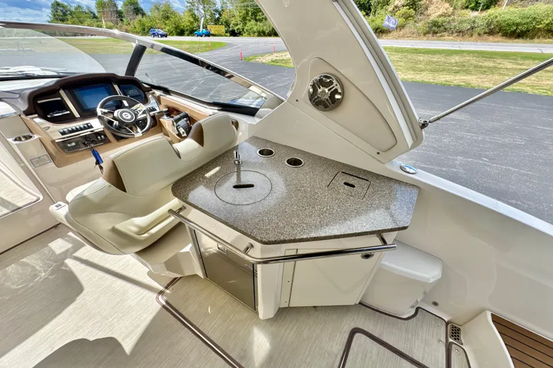 Slide: The Image of 2017 Chaparral 337 SSX boat interior with helm and kitchenette area. - 7