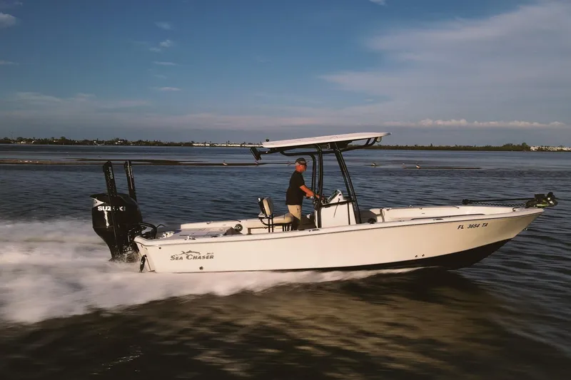 The Image of 2021 Sea Chaser 26 LX boat cruising on open water under clear skies. - 0