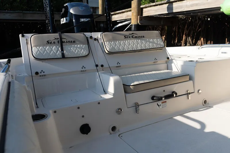 Slide: The Image of 2021 Sea Chaser 26 LX boat interior with cushioned seating and Suzuki engine. - 26