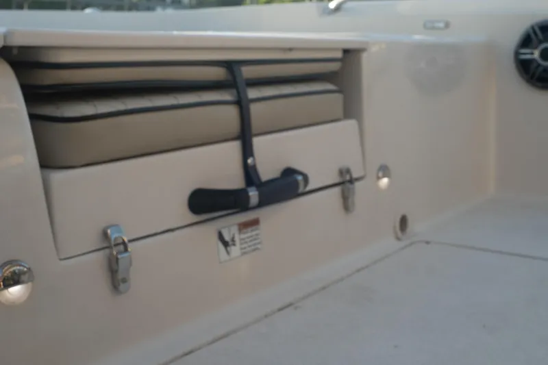 Slide: The Image of 2021 Sea Chaser 26 LX boat storage compartment with secure latches and cushioned seating. - 36