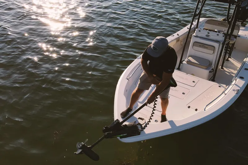 Slide: The Image of Man on 2021 Sea Chaser 26 LX boat adjusting trolling motor on water. - 41