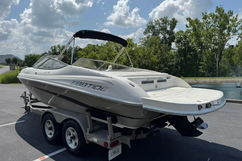 Slide: The Image of 2006 Ebbtide 2100 Bow Rider boat on trailer, parked near a pond under a cloudy sky. - 5