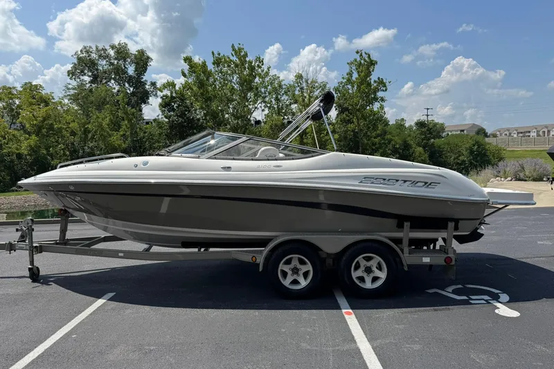 Slide: The Image of 2006 Ebbtide 2100 Bow Rider boat on trailer, parked outdoors under a sunny sky. - 6