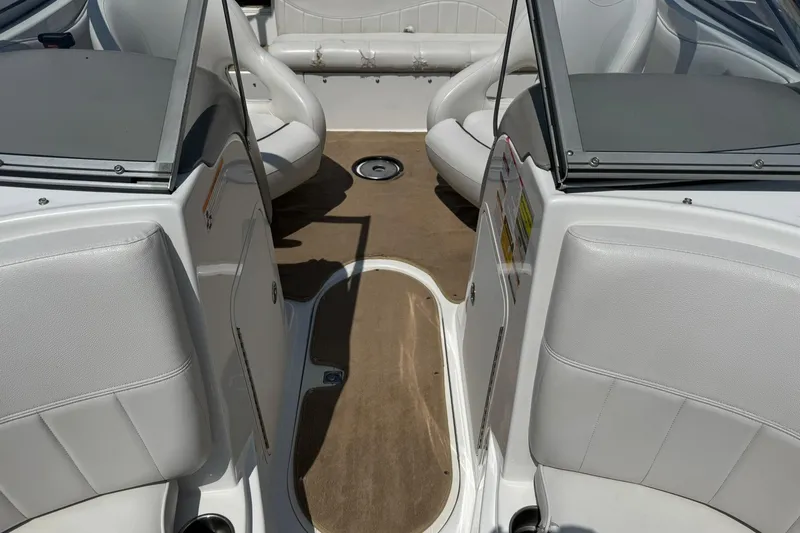 Slide: The Image of 2006 Ebbtide 2100 Bow Rider interior with beige carpet and white seating. - 8