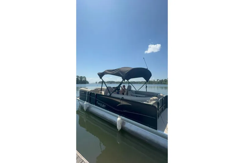 Slide: The Image of 2023 Premier Sunsation pontoon boat docked on a sunny lake. - 12