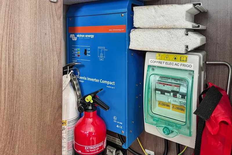 Slide: The Image of Electrical setup with Victron Energy inverter, fire extinguishers, and breaker box in Bali 4.2, 2023 model. - 100