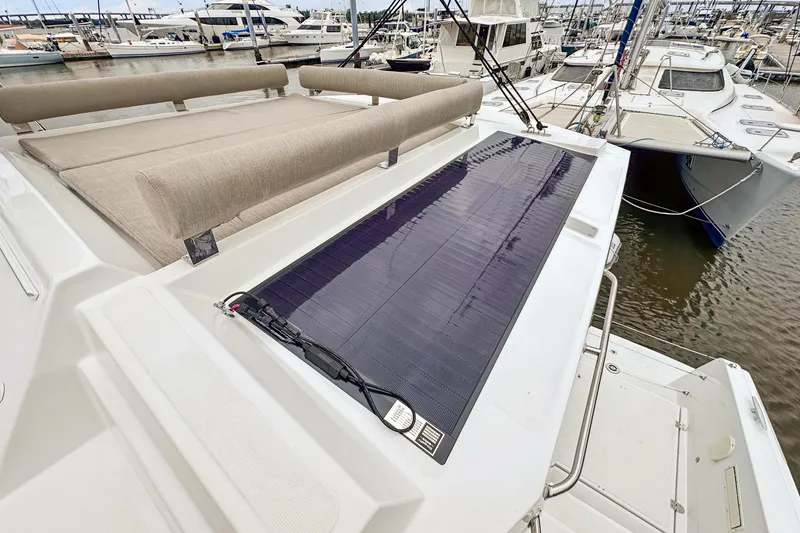Slide: The Image of 2023 Bali 4.2 yacht with solar panel and cushioned seating at marina. - 103