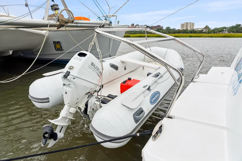 Slide: The Image of Inflatable boat with Suzuki outboard motor, docked on a Bali 4.2 catamaran, 2023 model. - 104