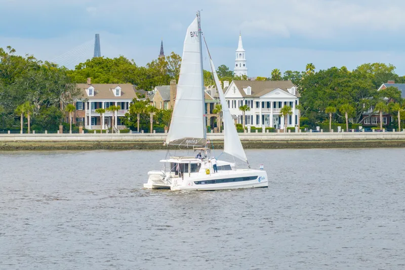 Slide: The Image of Sailboat Bali 4.2 cruising near elegant waterfront homes, 2023 model. - 111