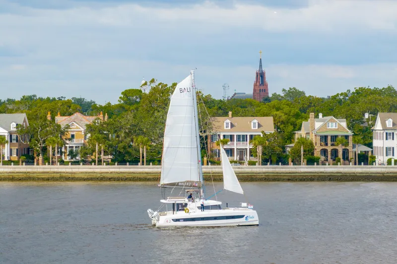 Slide: The Image of Sailboat Bali 4.2 cruising near waterfront homes, 2023 model. - 112