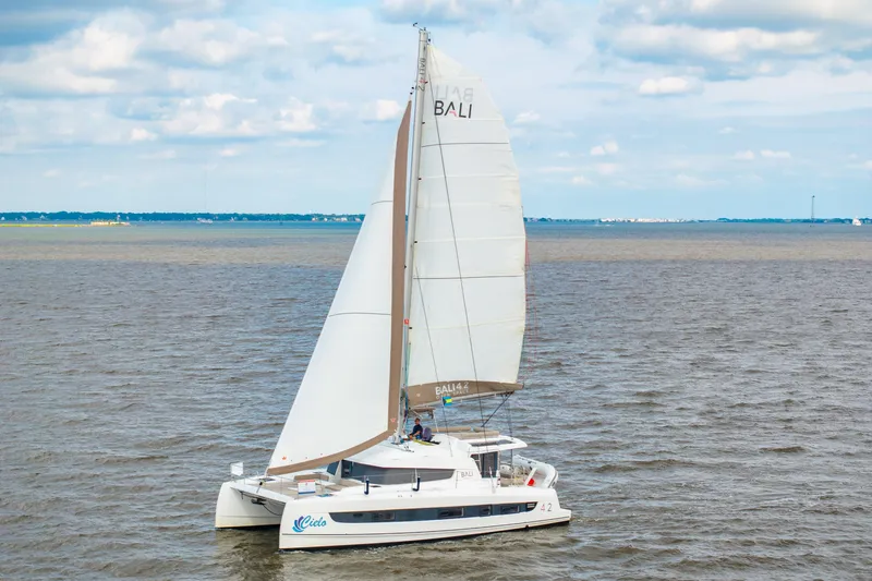 Slide: The Image of 2023 Bali 4.2 catamaran sailing on open water under a cloudy sky. - 117