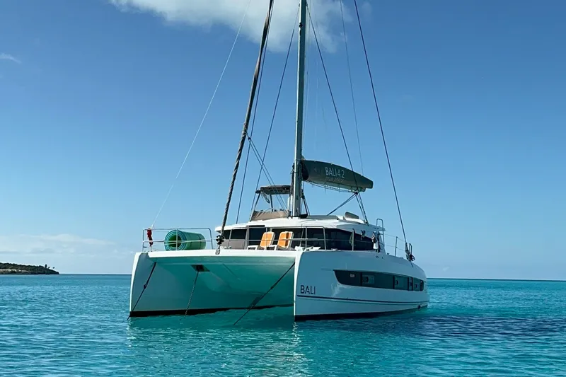 Slide: The Image of 2023 Bali 4.2 catamaran sailing on clear turquoise waters under a blue sky. - 121