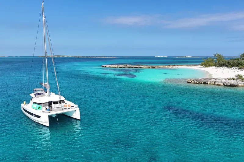 Slide: The Image of Sailing catamaran Bali 4.2, 2023 model, anchored in turquoise tropical waters near a sandy beach. - 122