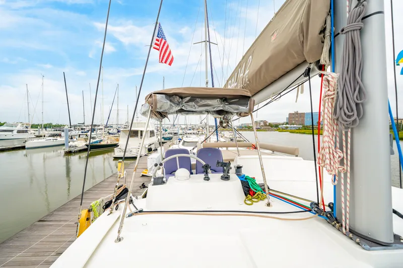 Slide: The Image of 2023 Bali 4.2 yacht docked at marina with American flag, clear sky. - 17