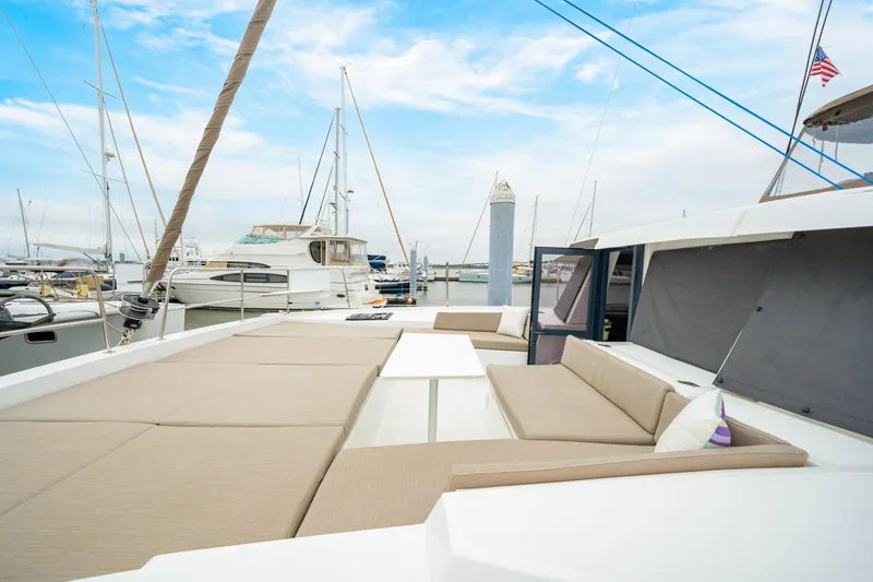 Slide: The Image of Luxurious 2023 Bali 4.2 catamaran with spacious deck seating in a marina setting. - 23