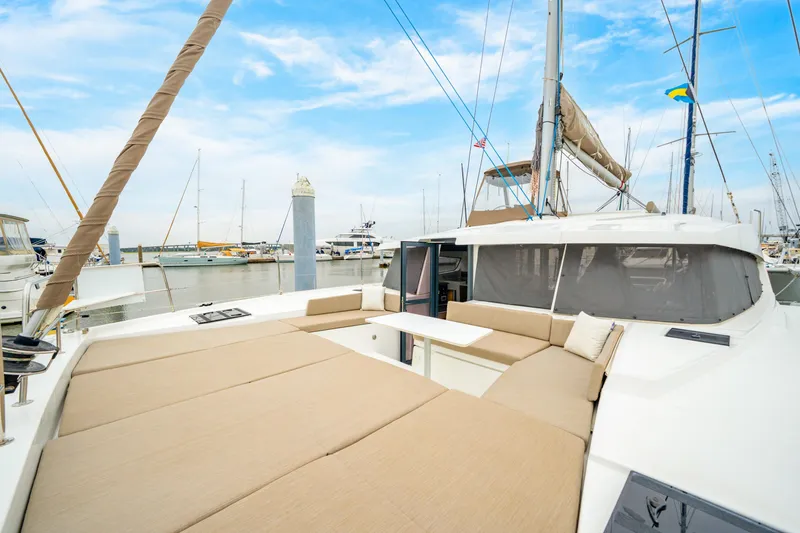 Slide: The Image of 2023 Bali 4.2 catamaran with spacious deck and seating, docked in marina. - 25