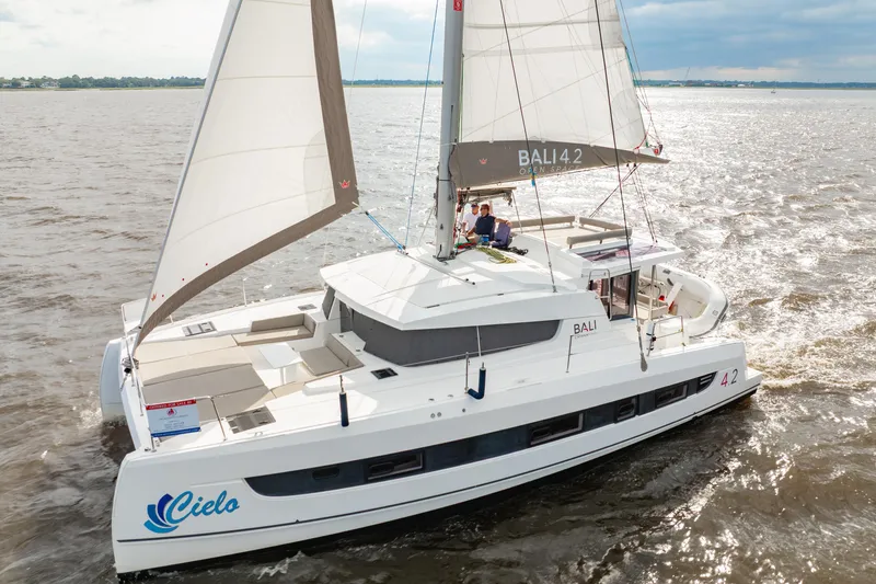 Slide: The Image of 2023 Bali 4.2 catamaran sailing on open water, featuring spacious deck and modern design. - 3