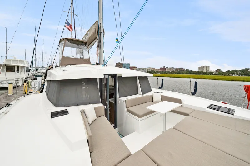 Slide: The Image of 2023 Bali 4.2 catamaran with spacious deck seating, docked in a marina. - 34